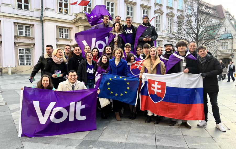 Členovia Volt Slovensko počas predvolebnej kampane v Bratislave. Členovia politickej strany Volt slovensko sa nachádzajú pred primaciálnym palácom v starom meste v Bratislave. Fotka vzniká počas letáčikovania v uliciach mesta. Politici držia vlajky strany Volt, slovenskú ale aj vlajku európskej únie, keďže sa jedná o jediné hnutie zasadzujúce sa o federalizáciu Európskej únie